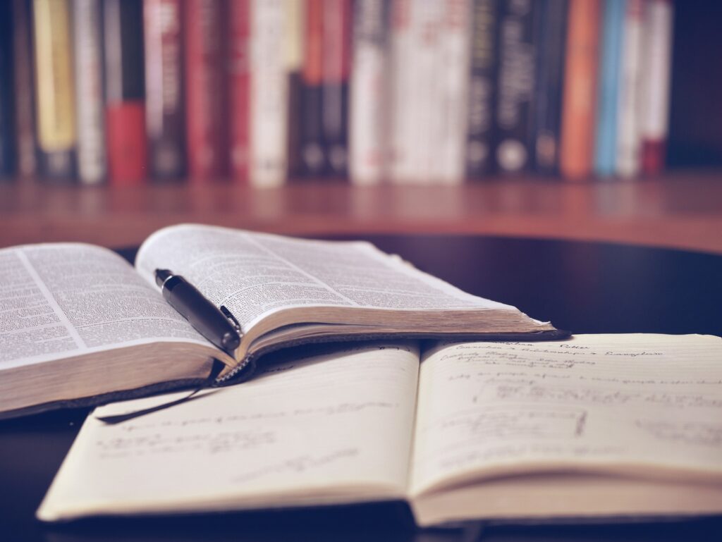 辞書とノートが一冊ずつ机に乗っている。辞書の上に黒いペンが一本