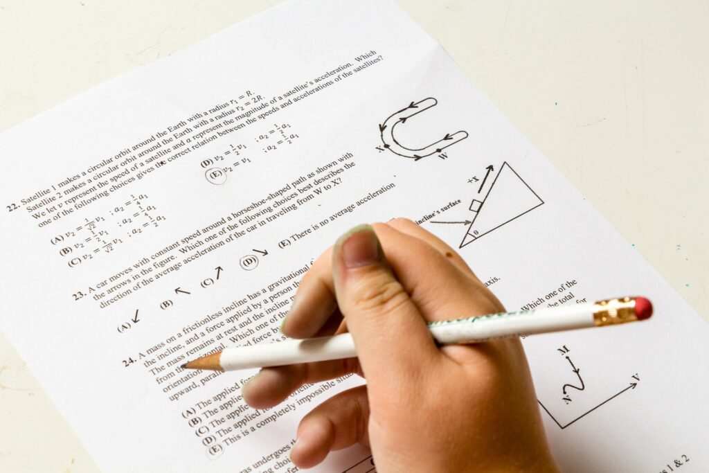 右手で白い鉛筆を持ち、数学の問題を解いている