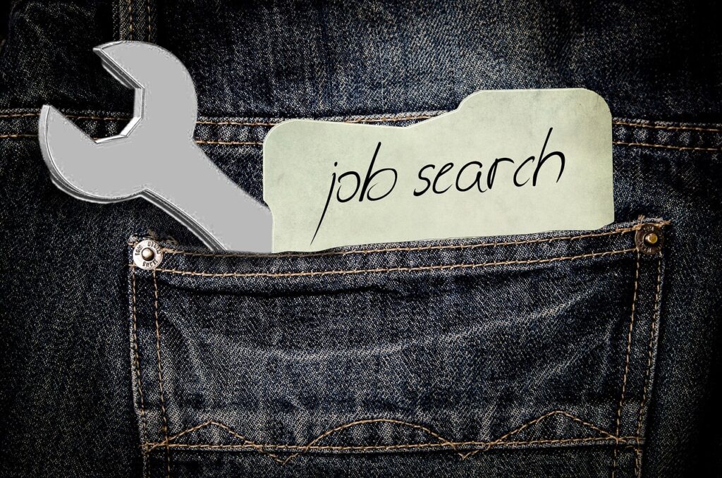 デニムのポケットにスパナとjob searchと書かれた紙