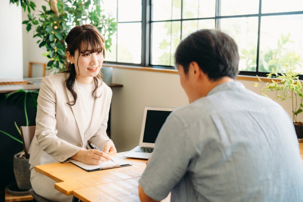 デスクで奥に女性、手前に男性が座りながら話している